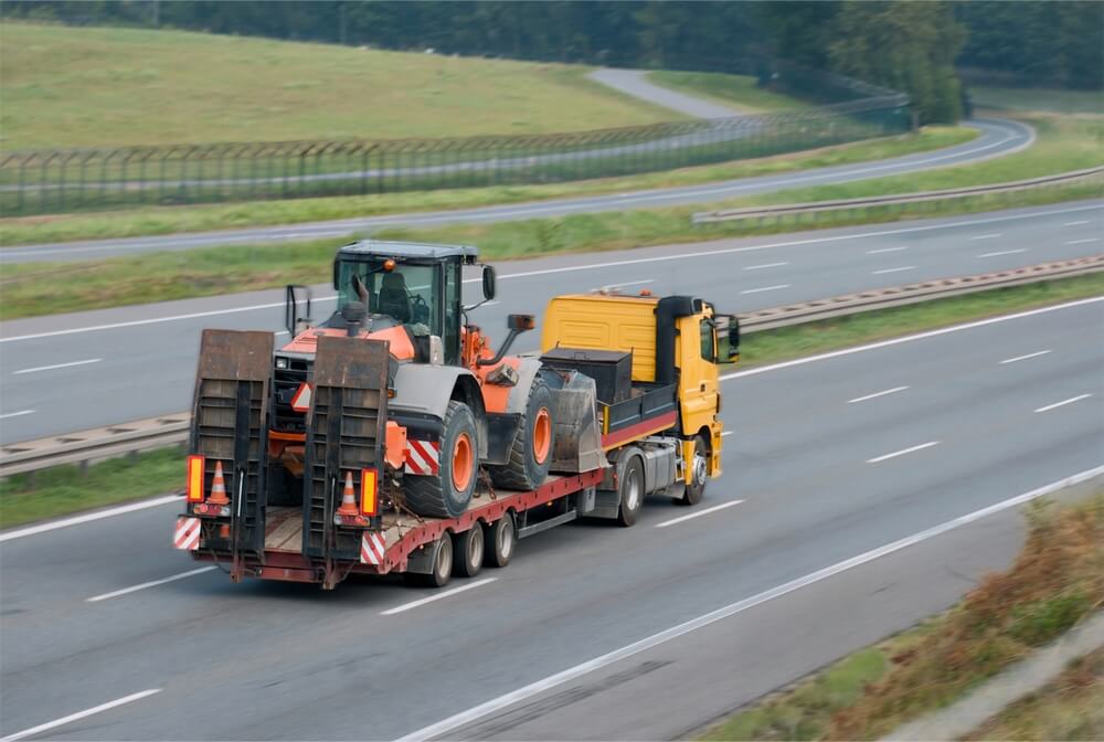 公道を走行する低床式トレーラー(ローローダー)